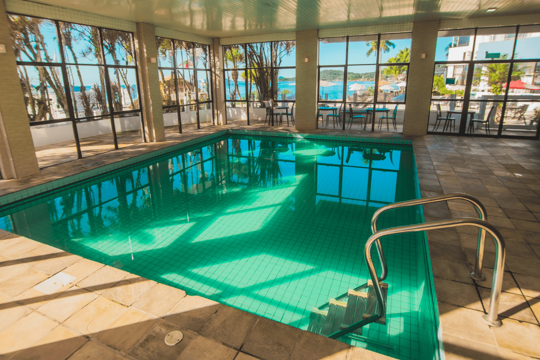 Piscina térmica coberta do Hotel VillaReal em São Francisco do Sul, com ambiente interno amplo, iluminação natural e vista para a Baía da Babitonga.